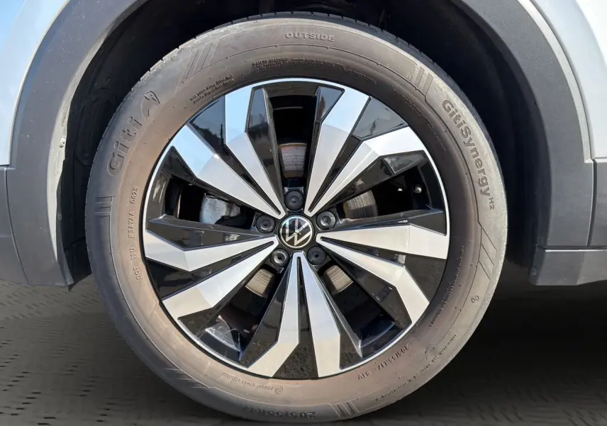 Gros plan sur la jante alliage 17 pouces bicolore du Volkswagen T-Cross reflet d'argent, avec pneu Giti Synergy.