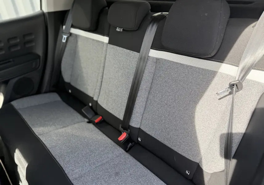 Vue intérieure de la banquette arrière en tissu gris et noir de la Citroën C3 2019, avec ceintures de sécurité visibles.