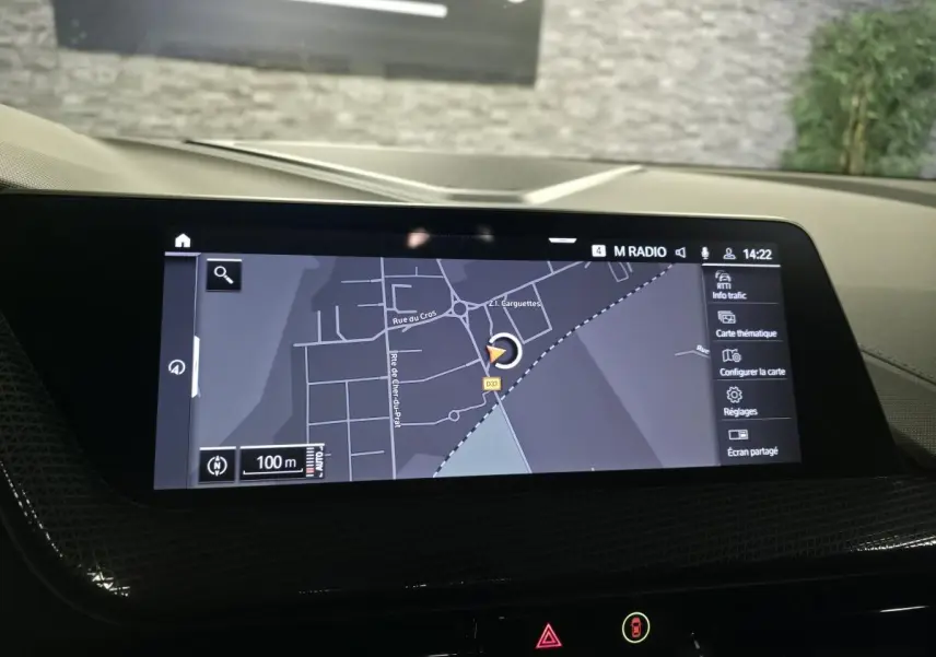 Écran tactile central de navigation BMW Live Cockpit dans une BMW Série 1 116d M Sport, vue intérieure.