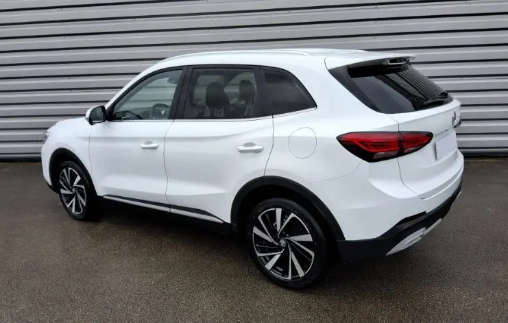 Vue 3/4 arrière droite du SUV MG ZS 1.5 Hybrid+ 197 Luxury en blanc Dover avec jantes noires et détails noirs contrastants.