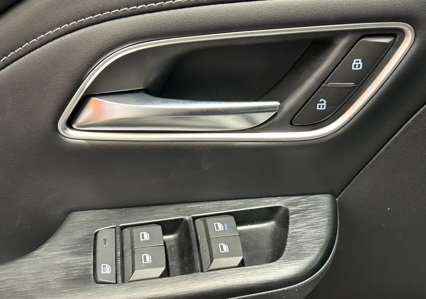 Poignée de porte intérieure côté gauche en cuir noir avec commandes de verrouillage et lève-vitres du MG ZS 1.5 Hybrid+ Dover White.