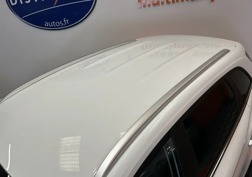 Vue en plongée sur le toit blanc Dover White d’un MG ZS 1.5 Hybrid+ 197 Luxury avec barres de toit argentées.