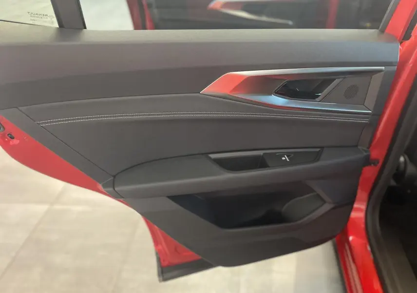 Intérieur côté gauche de la porte avant rouge du Renault Rafale 2025, avec garniture noire et surpiqûres blanches.