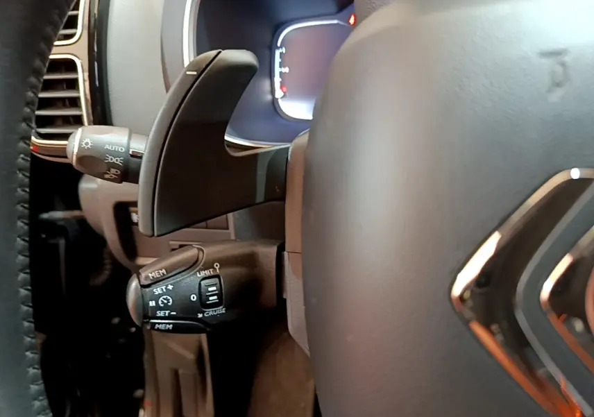 Gros plan sur la commande de régulateur de vitesse à gauche du volant cuir noir du Citroën C5 Aircross 2020.