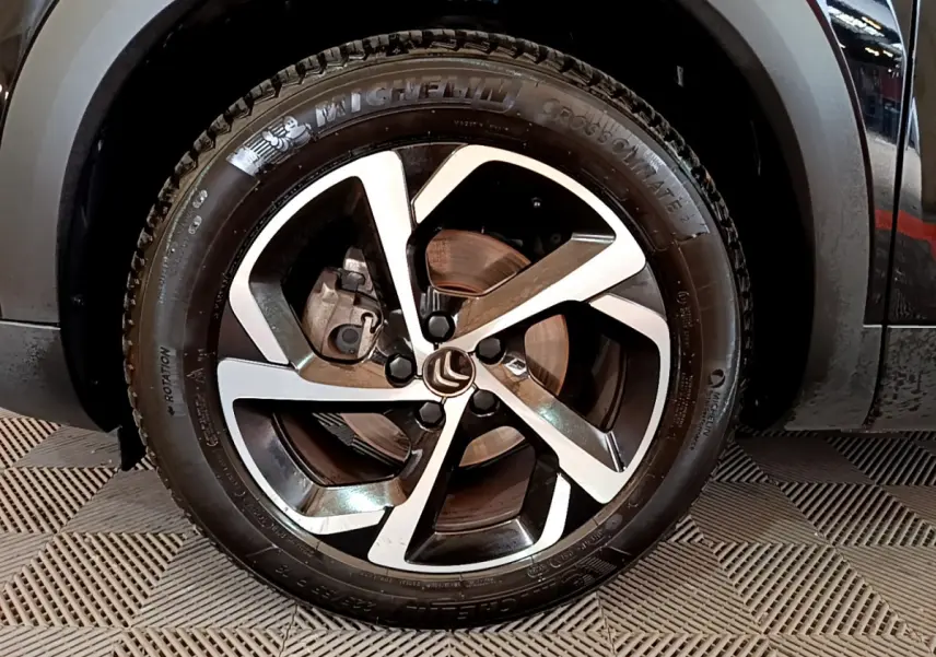 Gros plan sur la roue avant droite noire du Citroën C5 Aircross avec jante alliage bicolore et pneu Michelin.