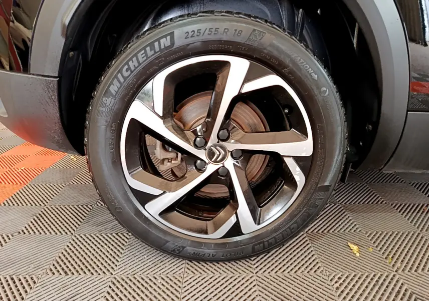 Gros plan sur la roue avant droite d’un Citroën C5 Aircross noir avec jante alliage bicolore et pneu Michelin.