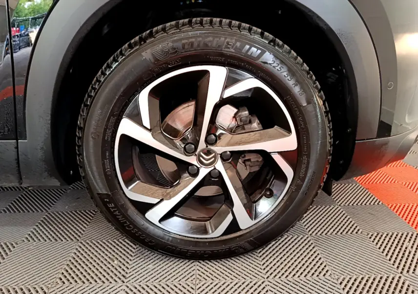 Gros plan sur la roue arrière droite d'un Citroën C5 Aircross noir, avec pneumatique Michelin visible et passage de roue gris.