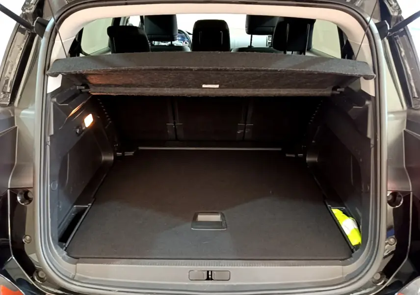 Coffre ouvert d'un Citroën C5 Aircross noir, vue arrière, montrant un espace de chargement spacieux et bien éclairé.