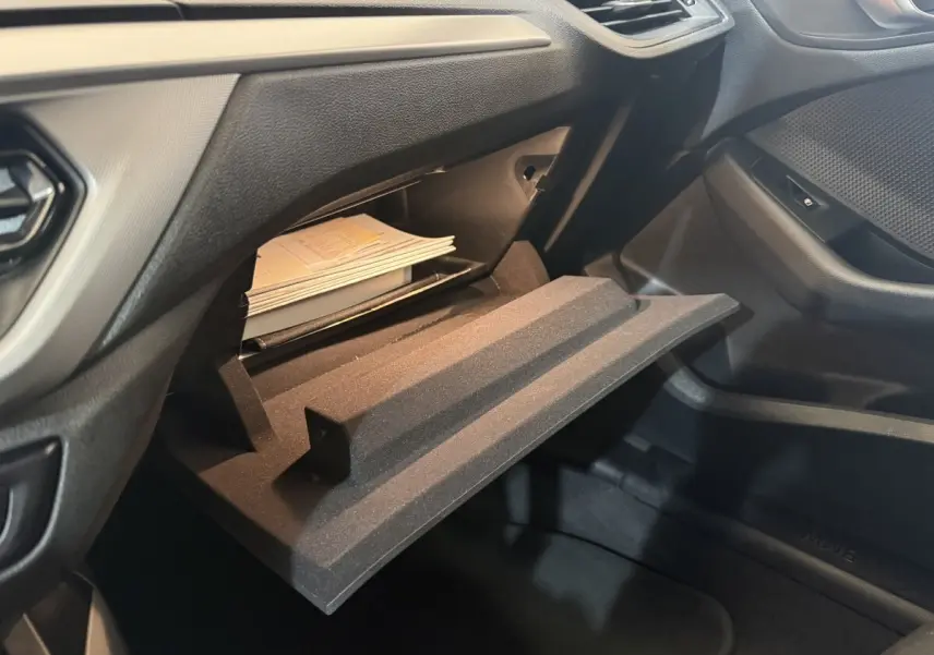 Vue intérieure côté passager de la BMW Série 1 116d Business Design 2022, boîte noire ouverte avec documents visibles.