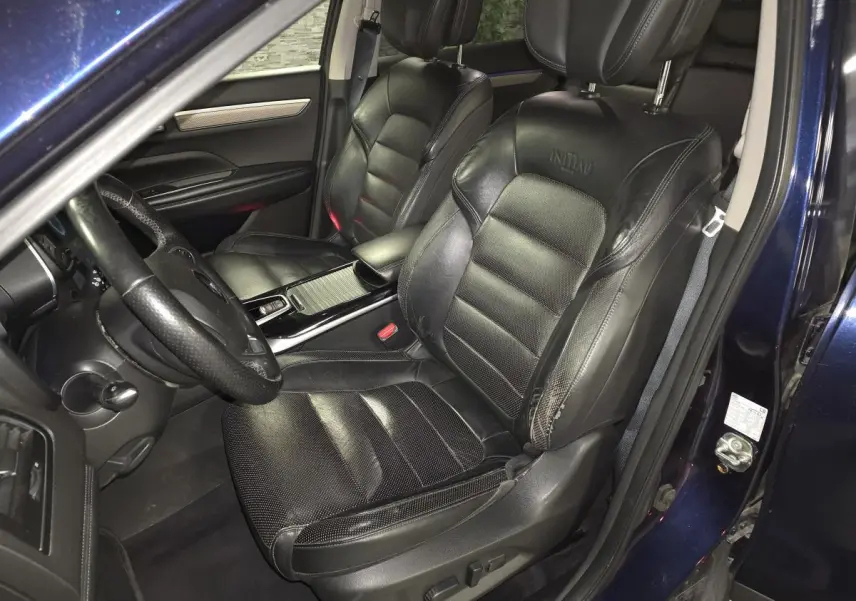 Vue intérieure côté conducteur du Renault Koleos bleu, sièges cuir Nappa noirs avec logo Initiale brodé.