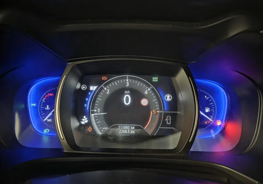 Vue rapprochée du compteur digital bleu et noir du Renault Koleos 2017 avec affichage kilométrique et indicateurs lumineux.