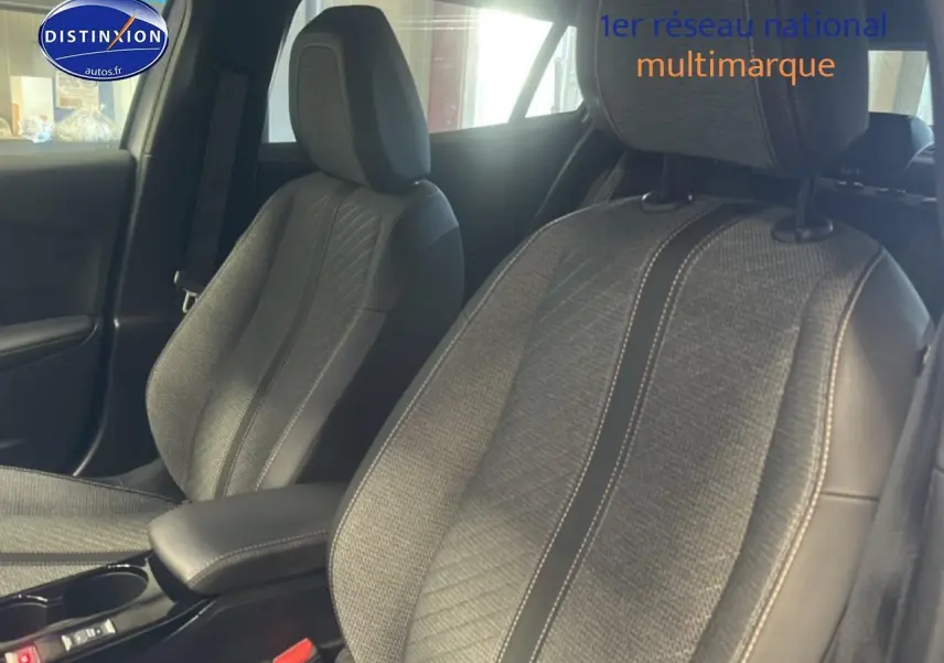 Vue intérieure rapprochée des sièges avant en tissu gris embossé avec surpiqûres contrastées d'un Peugeot 2008 2025.