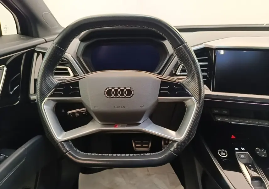 Vue frontale du volant cuir noir perforé et du tableau de bord digital de l'Audi Q4 E-TRON Sportback 2023.