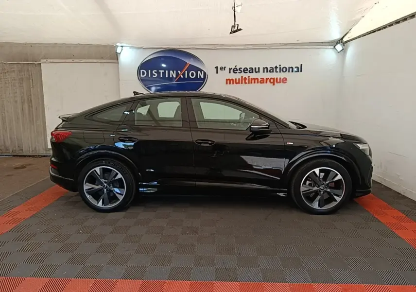 Audi Q4 E-Tron Sportback électrique noir, vue de profil côté gauche, avec jantes S Line et toit incliné.