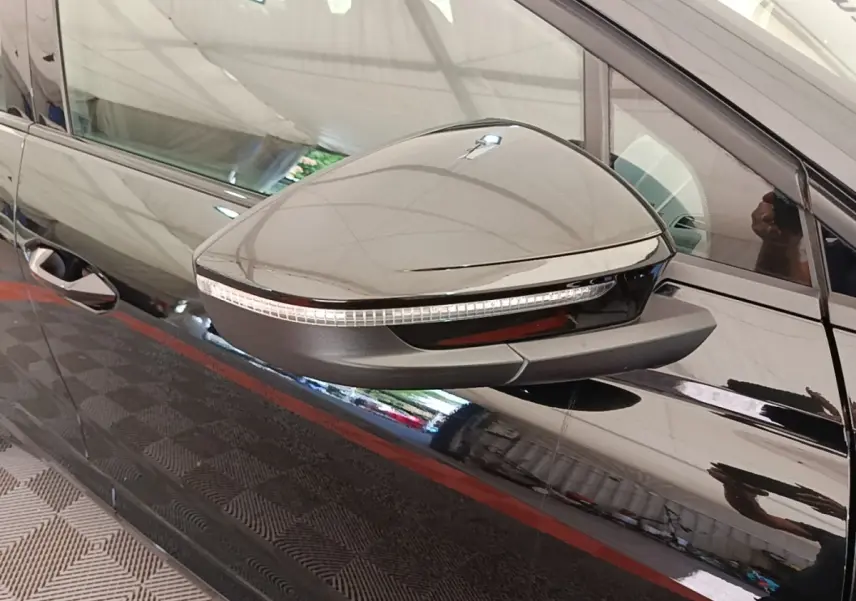 Rétroviseur droit noir brillant avec clignotant intégré sur Audi Q4 E-TRON Sportback noir, vue latérale rapprochée.
