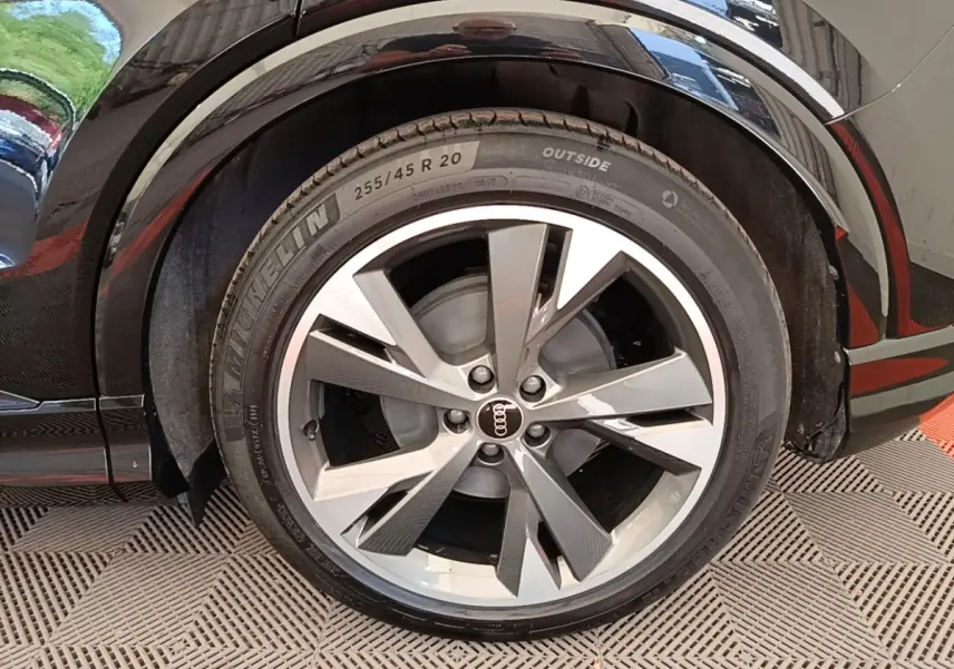 Gros plan sur la roue arrière droite noire d’un Audi Q4 E-TRON Sportback avec jante alliage à cinq branches doubles.