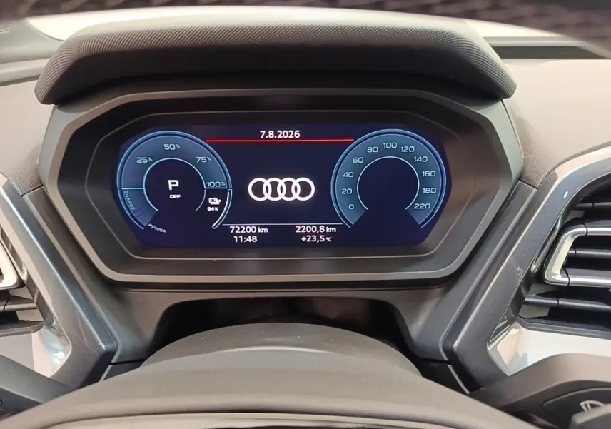 Vue rapprochée du combiné d'instruments numérique de l'Audi Q4 E-TRON Sportback affichant les compteurs et logo Audi.