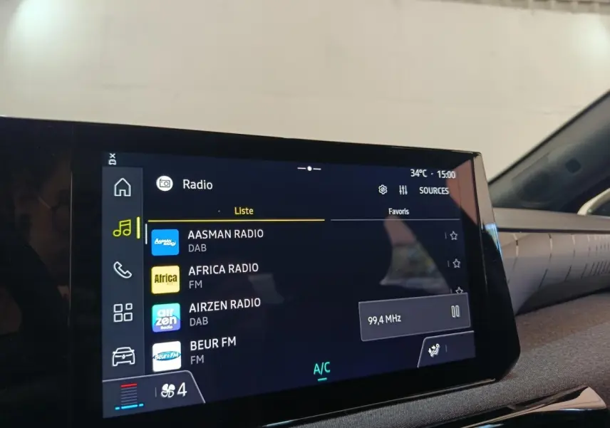 Vue intérieure centrée sur l'écran tactile multimédia de la Renault Clio 2026, affichant la liste des radios.