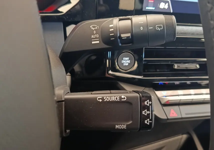 Gros plan sur la commande multifonctions et le bouton Start Engine Stop du tableau de bord intérieur de la Renault Clio bleu.