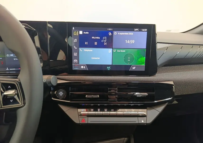 Vue intérieure centrée sur le tableau de bord noir brillant et l'écran tactile multifonctions de la Renault Clio bleu.