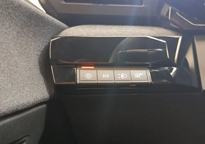Gros plan sur les boutons de commande du tableau de bord noir brillant de la Renault Clio bleu, version 2026.