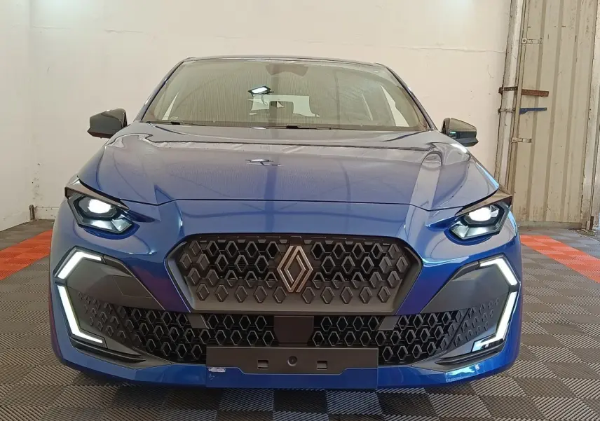 Vue frontale d'une Renault Clio Evolution TCe 115 bleu avec calandre hexagonale et feux LED allumés.