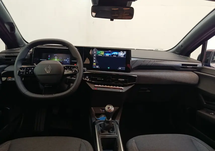 Vue intérieure avant de la Renault Clio bleu, volant multifonctions, écran tactile central et boîte manuelle visible.