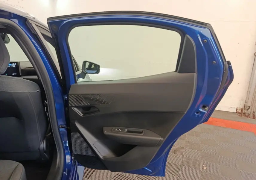 Vue intérieure de la porte arrière droite bleu de la Renault Clio 2026, avec habillage noir et commandes de fenêtre.