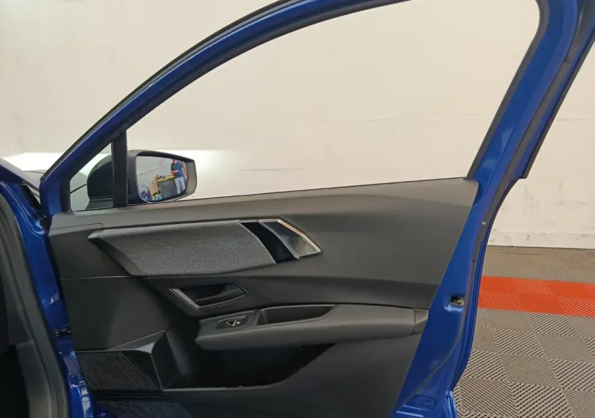 Vue intérieure de la porte avant gauche bleu Renault Clio 2026, avec garniture grise et commandes de vitre intégrées.