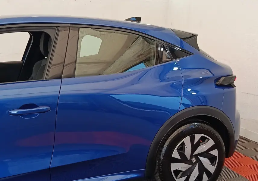 Profil côté gauche de la Renault Clio bleu 2026 avec jante au design géométrique et poignées de porte intégrées.