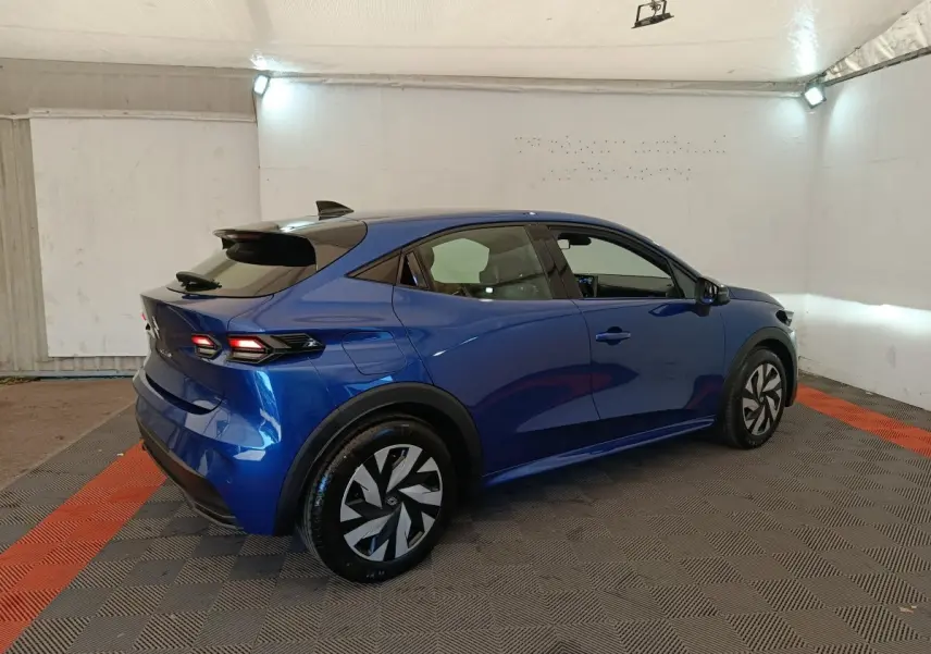 Vue 3/4 arrière droite d'une Renault Clio bleu 2026 avec feux arrière LED et jantes au design moderne.