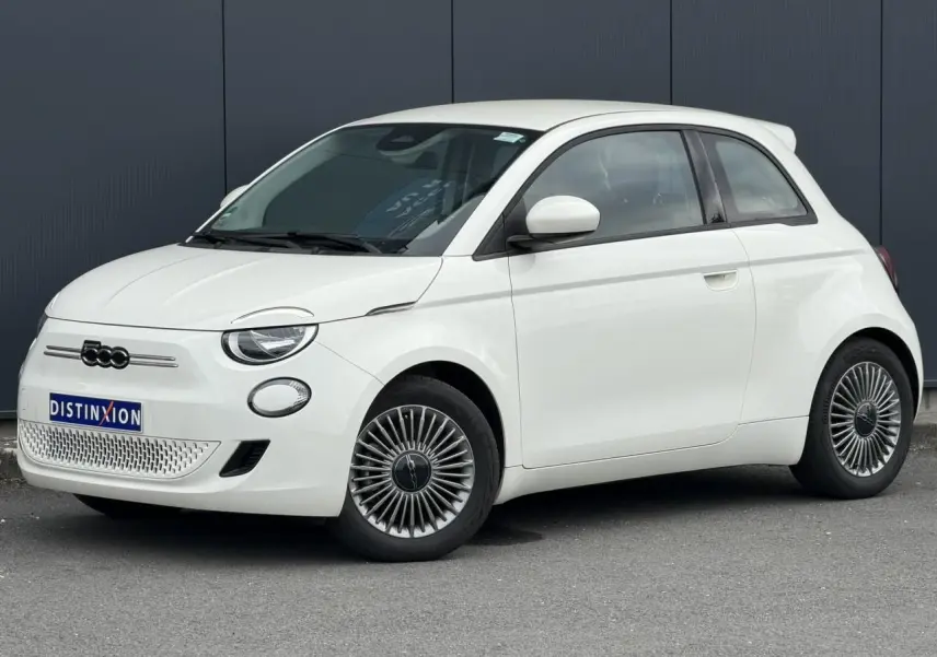 Fiat 500 électrique blanche vue 3/4 avant droit, avec jantes spécifiques et calandre sans grille.