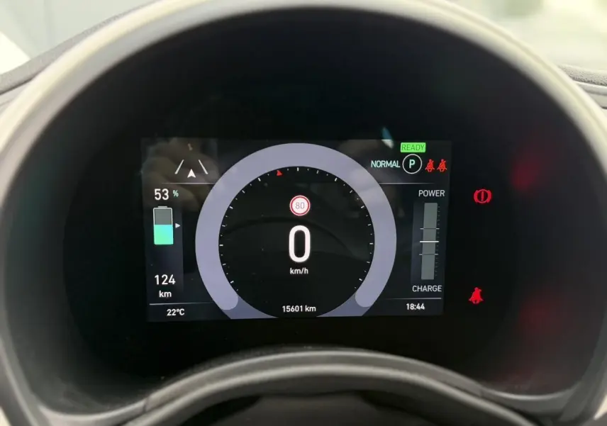 Vue rapprochée du tableau de bord numérique de la Fiat 500 électrique blanche, affichant la vitesse à 0 km/h et l'autonomie à 124 km.