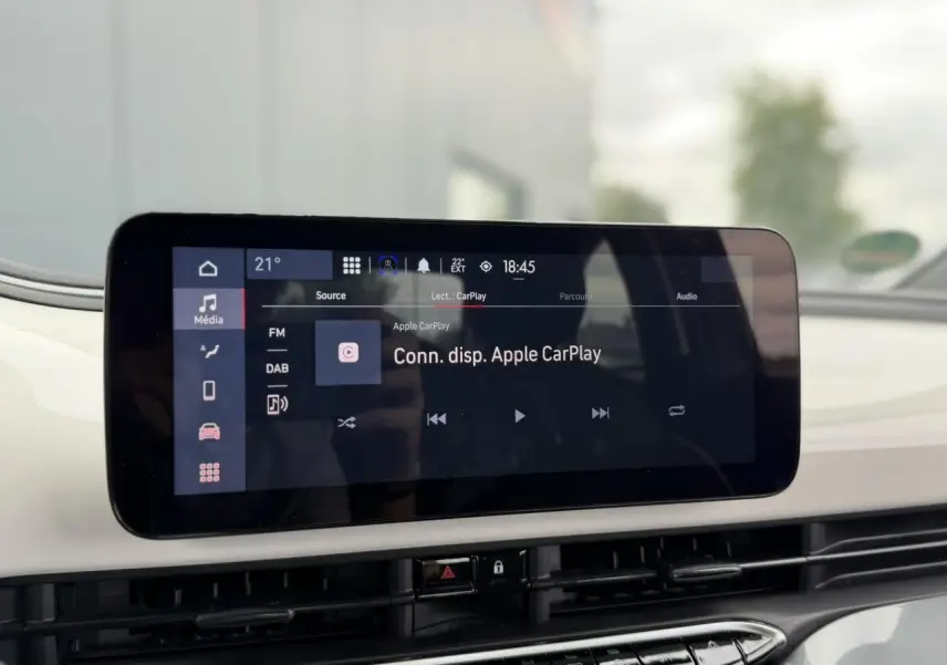 Écran tactile central affichant la connexion Apple CarPlay dans l’habitacle blanc d’une Fiat 500 électrique 2023.