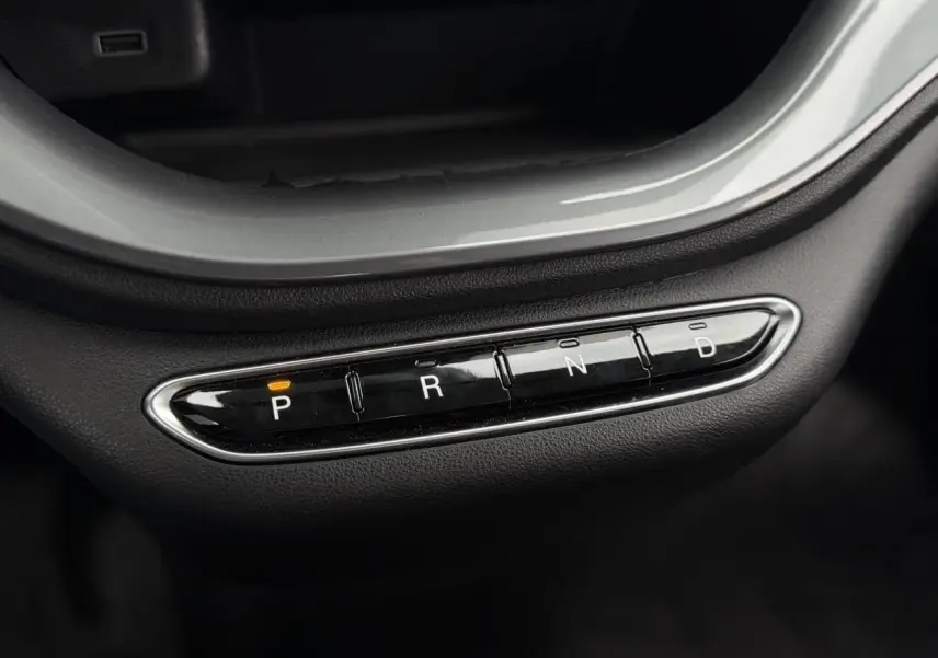 Gros plan sur la commande de boîte automatique noire avec indication orange sur "P" dans une Fiat 500 électrique blanche.
