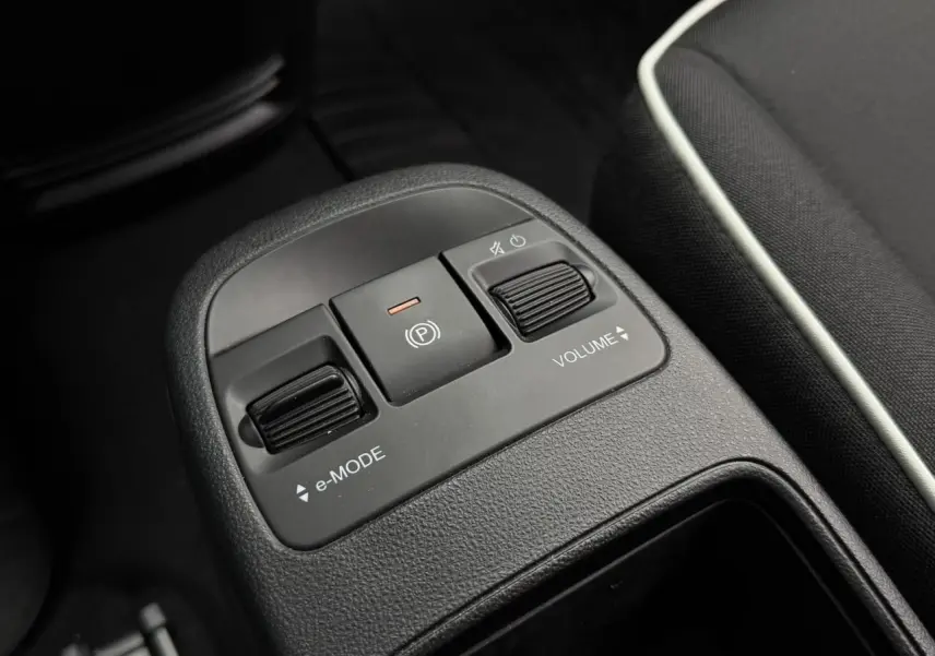 Gros plan sur la console centrale de la Fiat 500 électrique 2023, montrant les commandes e-Mode, frein à main et volume.