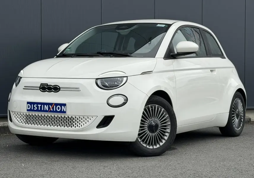 Fiat 500 électrique blanche vue 3/4 avant droit, avec jantes stylisées et calandre épurée.