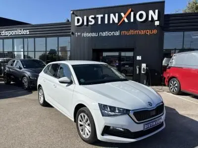 Vue 3/4 avant droite d'une Skoda Scala blanc glacier stationnée devant un concessionnaire Distinxion.