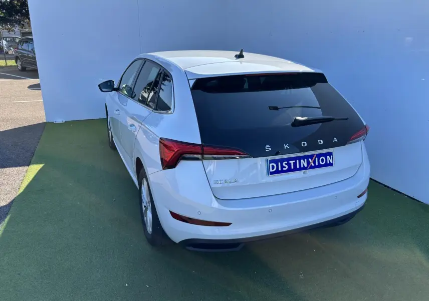 Vue 3/4 arrière droite d'une Skoda Scala blanche Glacier avec vitres arrière teintées et feux LED distinctifs.