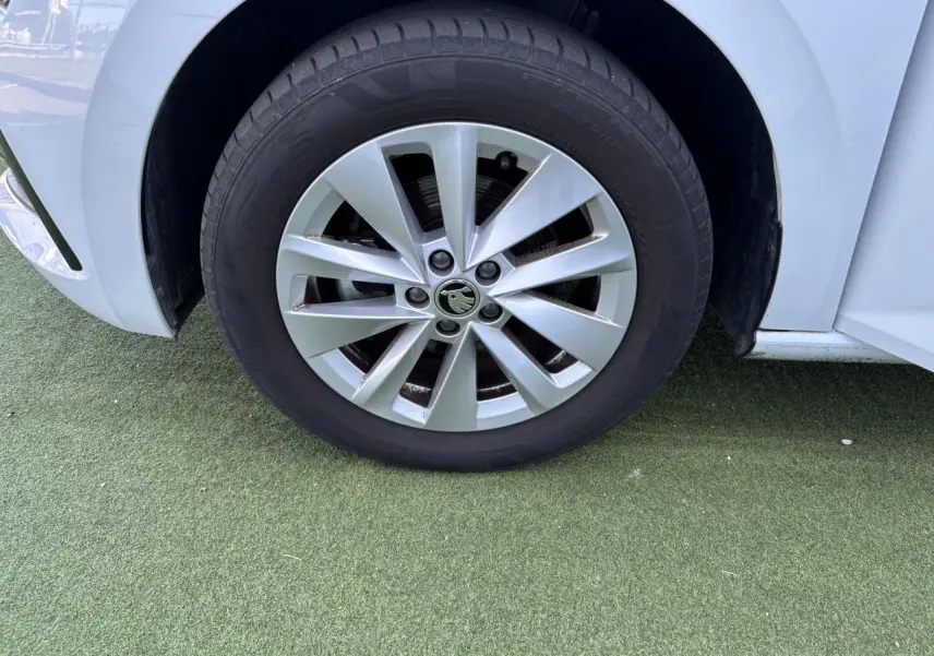 Gros plan sur la roue avant gauche blanche glacier d'une Skoda Scala 2024 avec jante alliage argent Sargas Aero.