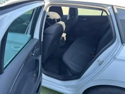 Vue intérieure côté gauche arrière de la Skoda Scala blanc glacier 2024, montrant la banquette arrière et les portes ouvertes.