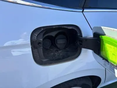 Gros plan sur la trappe à carburant ouverte côté gauche d'une Skoda Scala blanc glacier 2024.