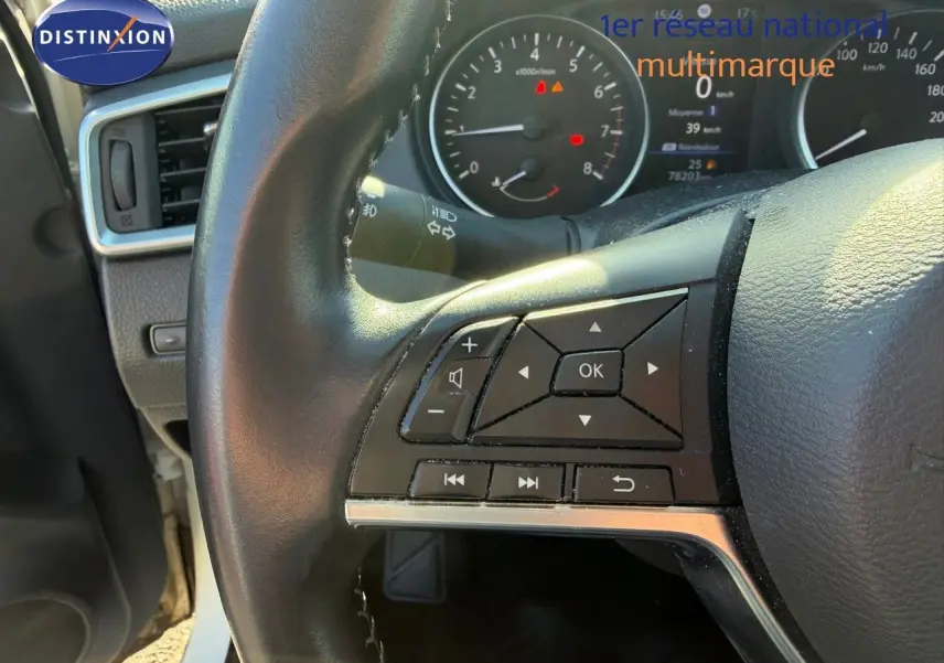 Gros plan sur le volant côté gauche du Nissan Qashqai blanc nacré 2019, avec commandes multifonctions visibles.