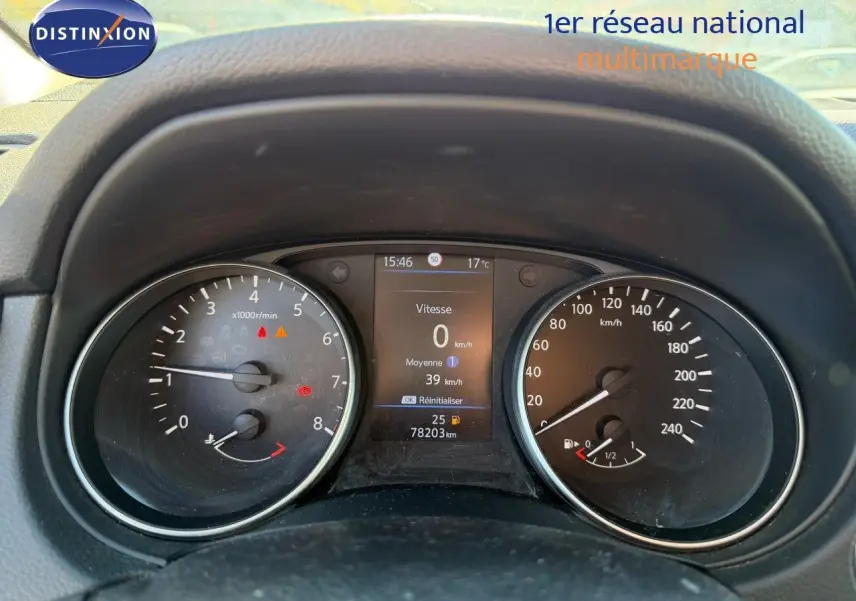 Vue rapprochée du tableau de bord du Nissan Qashqai blanc nacré, affichant compte-tours, vitesse et jauge carburant.