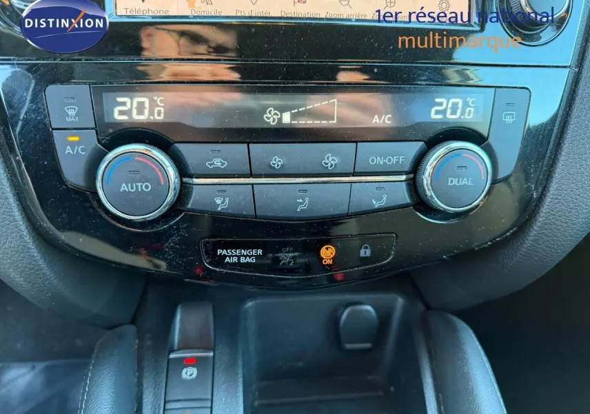 Vue rapprochée du tableau de bord du Nissan Qashqai 2019, montrant la climatisation automatique avec affichage digital à 20°C.
