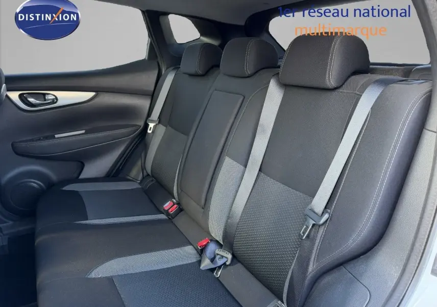 Vue intérieure du siège arrière côté gauche d'un Nissan Qashqai blanc nacré, avec ceintures de sécurité et appuie-têtes visibles.