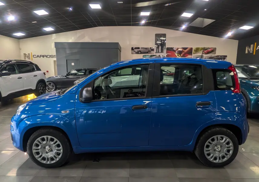 Vue de profil côté gauche d'une Fiat Panda 1.0 Hybrid 2025 en Bleu Italia, compacte et moderne en showroom.