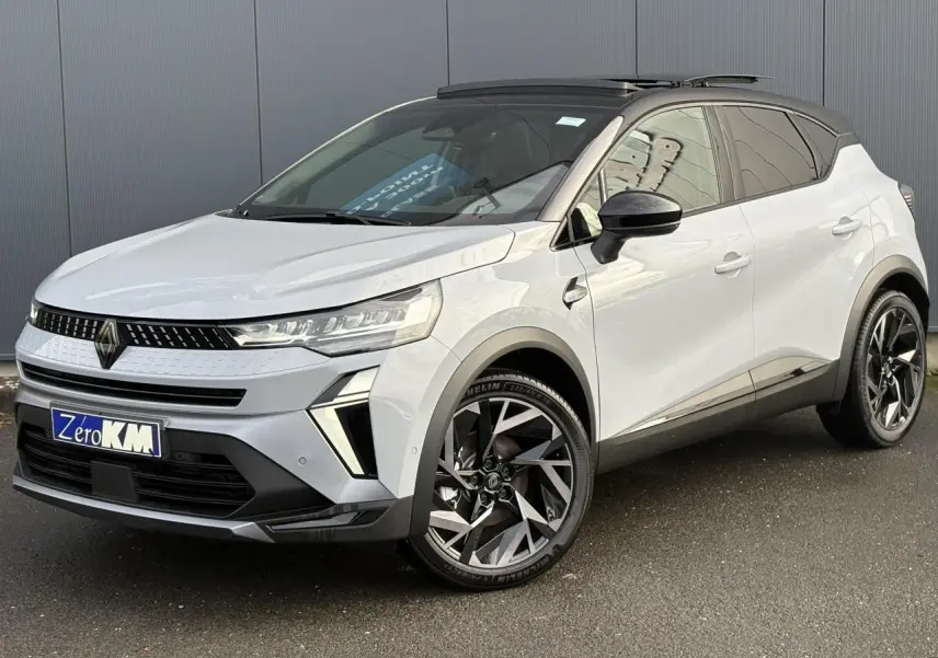 Renault Captur 2025 gris clair avec toit noir ouvrant, vue 3/4 avant droit, jantes alliage distinctives.
