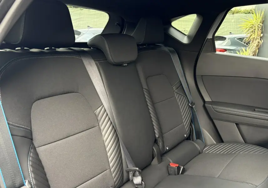 Vue intérieure côté droit de la banquette arrière noire avec surpiqûres bleues du Renault Captur Esprit Alpine 2025.