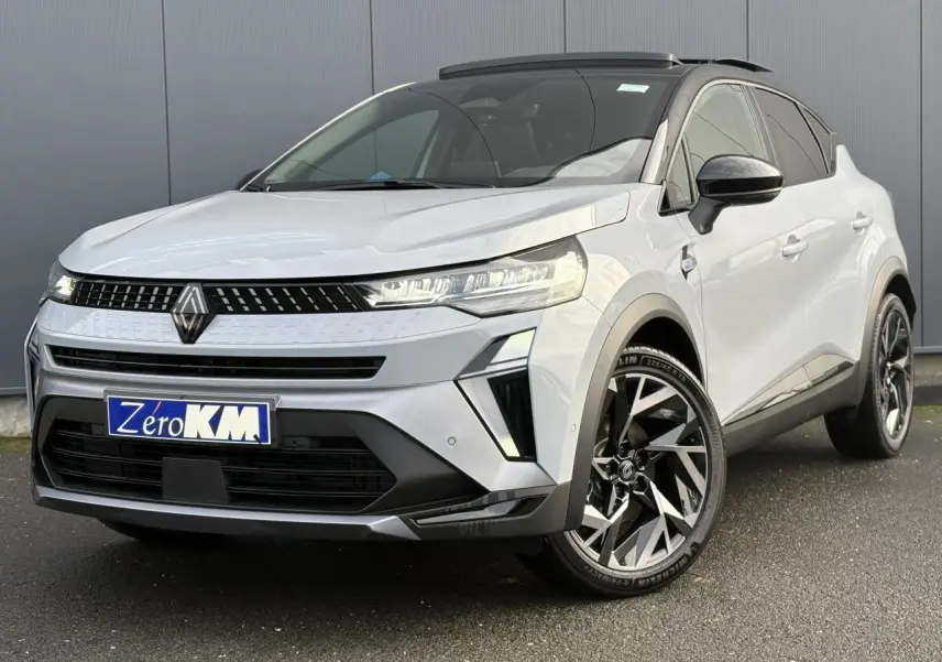 Vue 3/4 avant droit du Renault Captur gris clair avec toit noir et jantes alliage noires et argentées.